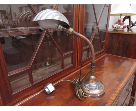 An Art Deco desk lamp with flixible stem to the brass and copper base, with chrome shell-shape shade