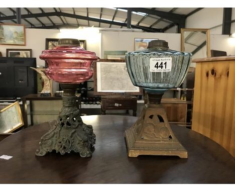 A Victorian cranberry glass oil lamp and 1 other, both missing burners