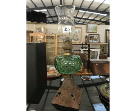 A Victorian green glass font oil lamp with cast iron base