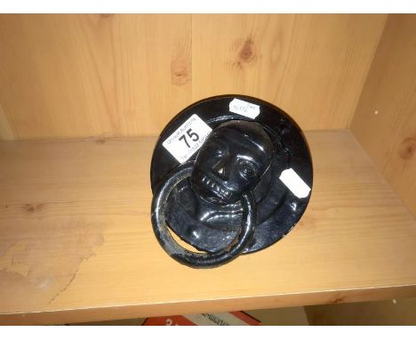 A round antique door knocker with head feature