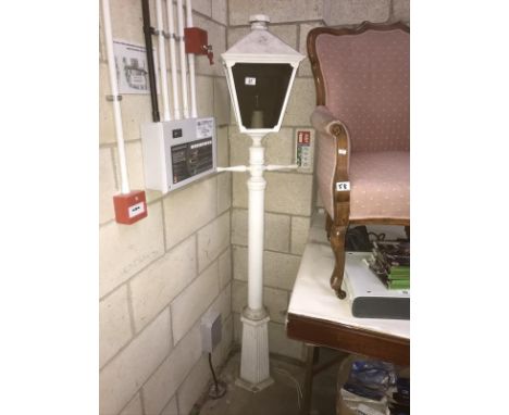 A white painted metal street lamp