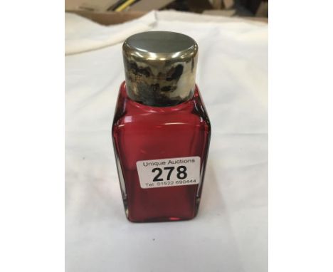 A ruby scent bottle with white metal top