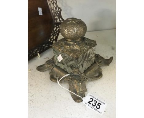 A decorative glass and metal inkwell