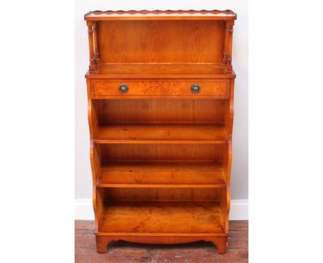 A small yew wood veneered Waring &amp; Gillow bookcase, with open shelf, above a single drawer over three, graduated shelves,