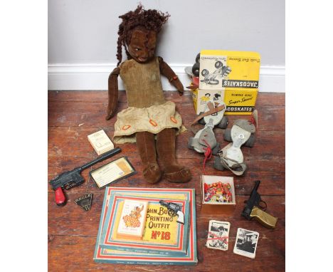A vintage black cloth musical doll circa 1930s, together with two pairs of roller skates, Man from Uncle kit, toy guns, John 