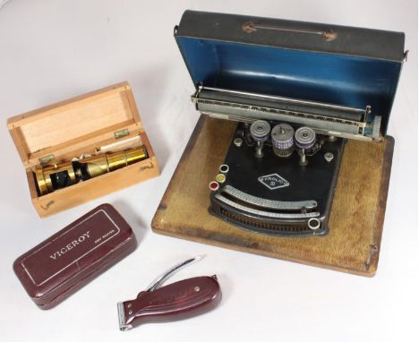 A Frolio, Model III portable typewriter on wooden base with black metal cover, together with a brass field microscope in fitt