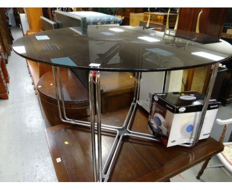 A smoky glass circular studio dining table on chrome supportscondition report:Glass top is good just light surface scratches,