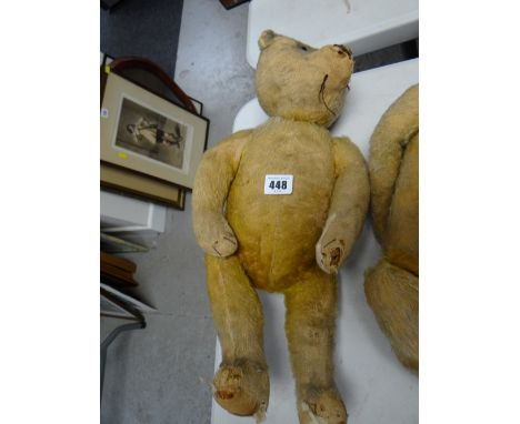 A vintage straw stuffed teddy bear with head movement by turning the the tail