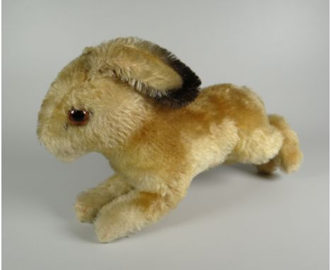 A STEIFF SOFT-TOY RABBIT in leaping pose and with glass eyes, label and stud to ear, 22cms long (BBC Bargain Hunt)
