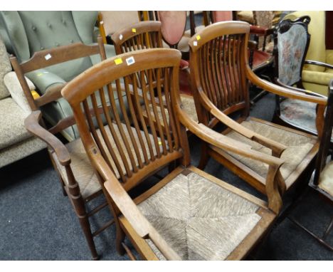 A pair of light oak rush seated spindle backed armchairs together with two other similar rush seated chairs