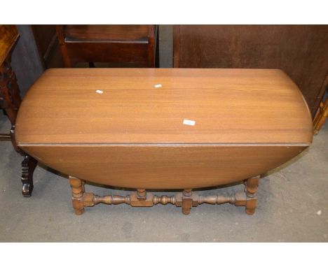 An Ercol oval drop leaf coffee table on turned legs