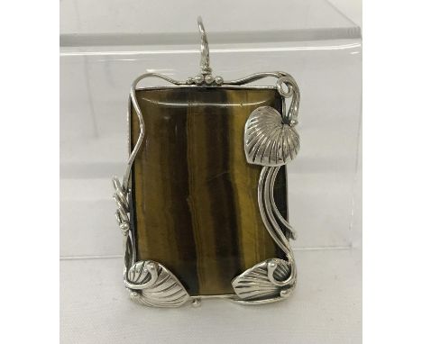 A large rectangular shaped Tiger's eye pendant framed in an Art Nouveau style 925 silver mount.   Approx. 6cm tall (with bale