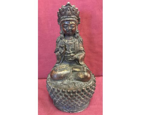 A Chinese hollow bronze figure of a deity sitting upon a lotus flower. With gilt detail.   Approx. 28cm tall.