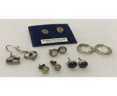 6 pairs of silver and white metal earrings in drop, hoop and stud styles.  To include garnet cabochon set studs and shell and