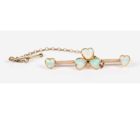 A gold and opal bar brooch, the centre designed as an opal set three leaf clover motif, otherwise mounted with a heart shaped