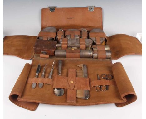 A George V silver travelling vanity set with engine turned decoration, including two hairbrushes, soap box, three cylindrical