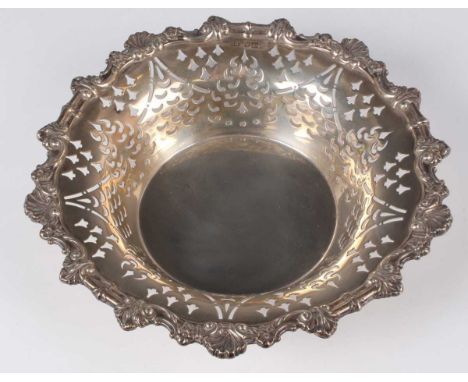 An Edwardian silver circular bowl with pierced tapering sides and cast scallop shell and foliate rim, London 1907 by Harrison