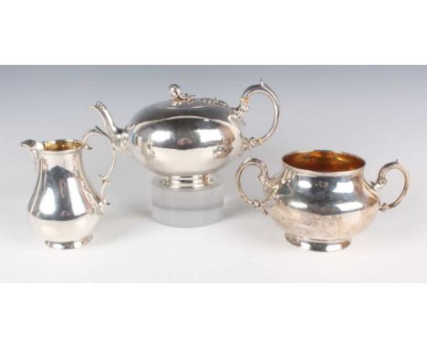 A Victorian silver three-piece tea set of squat circular form with scroll handles, comprising teapot with bud finial, milk ju