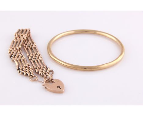 A 9ct yellow gold bangle, stamped 9ct, together with a 9ct rose gold gate bracelet with padlock clasp, four links wide, the i