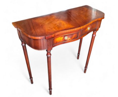 A reproduction flamed mahogany serpentine console table