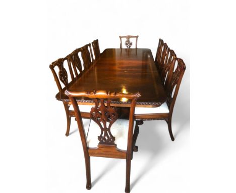 A reproduction extending flamed mahogany D-end dining table with a set of ten Chippendale Revival mahogany dining chairs, ver