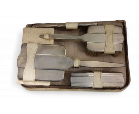 A silver four piece dressing table set, comprising hand mirror, hair brush, clothes brush and comb,&nbsp; engine turned, Walk