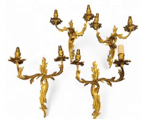 A pair of gilt metal two light, two branch side lights, cast with leafy scrolls, 32cm high;&nbsp; another, pair, similar (4)
