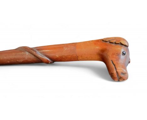 A 19th century folk art walking stick, the pommel carved as the head of a dog, the cane with entwined snake, brass pinwork ey