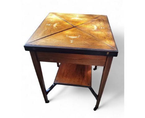 An Edwardian rosewood and marquetry envelope card table, square top with four folding leaves, inlaid with urns and swags, enc