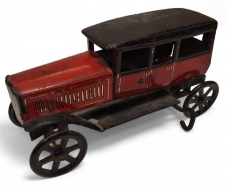 A pre-war Wells Brimtoy tinplate clockwork limousine with driver, red body, black, roof, wings and running boards, 15cms long