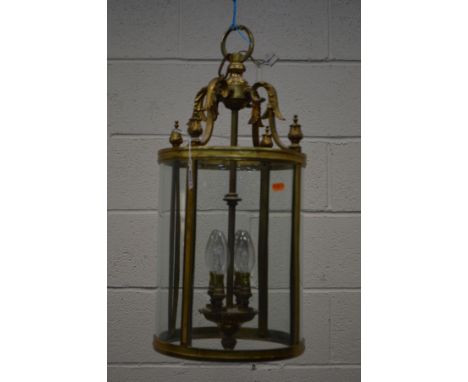 A BRASS CYLINDRICAL HALL LANTERN, with rounded glass panels, diameter 26cm x drop 57cm