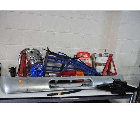 A COLLECTION OF AUTOMOTIVE PARTS AND TOOLS including axle stands, ramps, a Japanese taillight, a bumper, a pair of brake disc