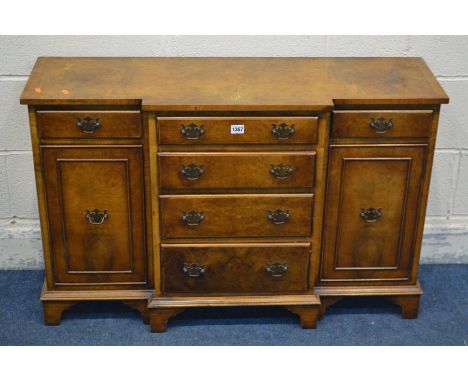A SMALL REPRODUCTION WALNUT AND CROSSBANDED BREAKFRONT SIDEBOARD with six various drawers and two cupboard doors, on bracket 