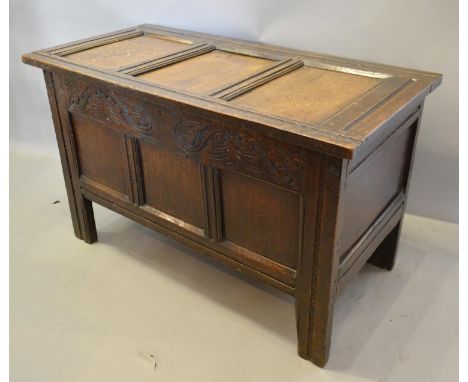 A George III Oak Small Coffer, the hinged top above a carved frieze and three panel front flanked by stiles, 100 cms wide, 48