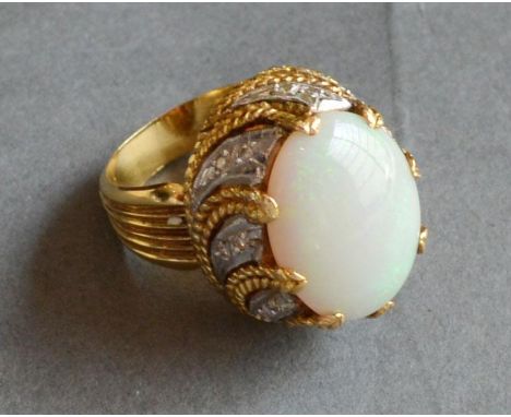 An 18ct. Gold Opal and Diamond Cluster Ring with a large oval cabochon opal above a diamond set tiered shoulder 16.8 gms 