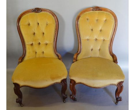 A Pair of Victorian Walnut Drawing Room Spoon Back Chairs, each with a carved and button upholstered back above a serpentine 