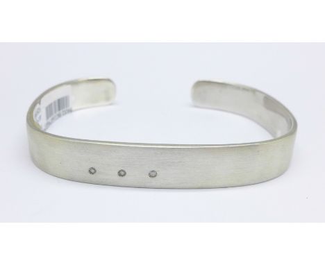 A silver bangle set with three small diamonds, 40g 