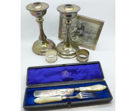 A pair of silver candlesticks, one a/f, a silver photograph frame, a Victorian silver and mother of pearl handled knife and f