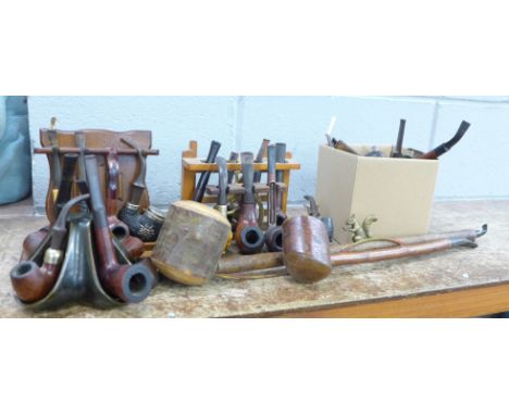 A large collection of pipes, five pipe racks and stands and a cased Meerschaum pipe, a/f 