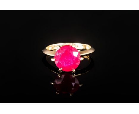 Ruby Solitaire Ring, 5.5cts of round cut ruby in a 9ct gold, six prong setting, allowing the generous stone to be seen from a