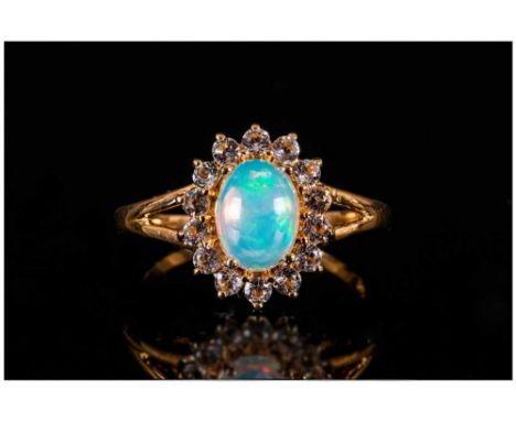 Opal and White Topaz Ring, an oval cut cabochon opal of over 1ct, with a good display of colours, framed with .25ct of round 