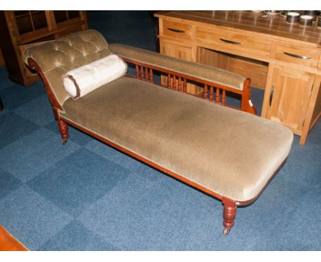 Chaise Lounge in olive green upholstered fabric. With button back cushion and spindled back. Terminating on castor feet.