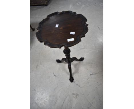 A 1920s piecrust tripod table having ball and claw feet