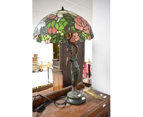 A vintage figural bronze effect table lamp with tiffany style shade