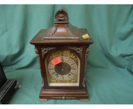 Large mantel clock in wood surround decorative top, gold metal face with Roman numerals