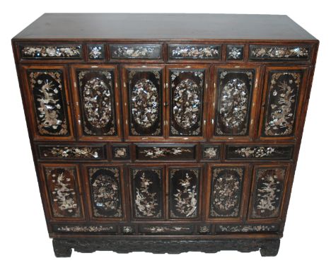 A Chinese camphorwood and mother of pearl inlaid cabinet inset with numerous panels decorated with butterflies, dragons, frui