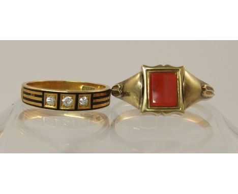 Two mourning rings an early Victorian example with a swivel signet, mounted with a carnelian to one side and a woven hair pan
