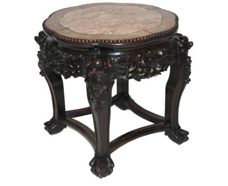 A Chinese hardstone plant pedestal with inset marble top above a pierced blossoming frieze and on grotesque mask scroll legs,