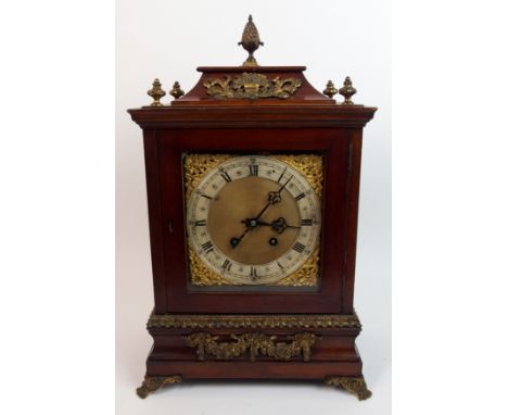 A mahogany and gilt metal bracket clock with pineapple finial above a silvered ring chapter enclosed by brass foliate spandre