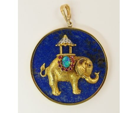 A 14ct gold lapis lazuli elephant pendant the two dimensional elephant with ruby, diamond and opal decorated howdah on his ba